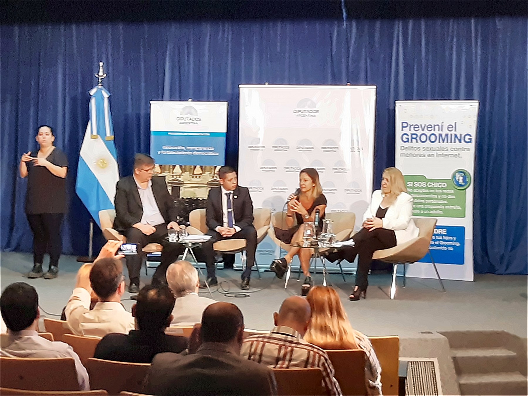 Panel en la Cámara de Diputados de la Nación con carteles del programa Innovación, transparencia y fortalecimiento democrático y de la campaña Prevení el Grooming